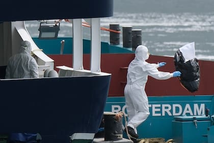 Operarios vestidos con equipos de protección retiran la basura del crucero MV Hondius a su llegada al puerto de Rotterdam, Holanda, el 18 de mayo de 2026.