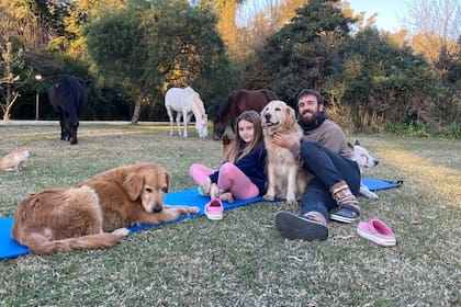 Oscar Ahumada, en su remanso, junto a una de sus hijas, Sofía, sus mascotas y los caballos en su campo en las afueras de Zárate