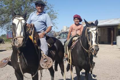 Óscar y su hijo mientras llevaban rollos de alimento para los animales