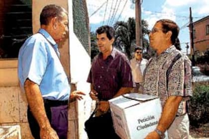 Oswaldo Payá (centro) y otro disidente, Antonio Díaz, con un guardia de seguridad antes de entregar el pedido