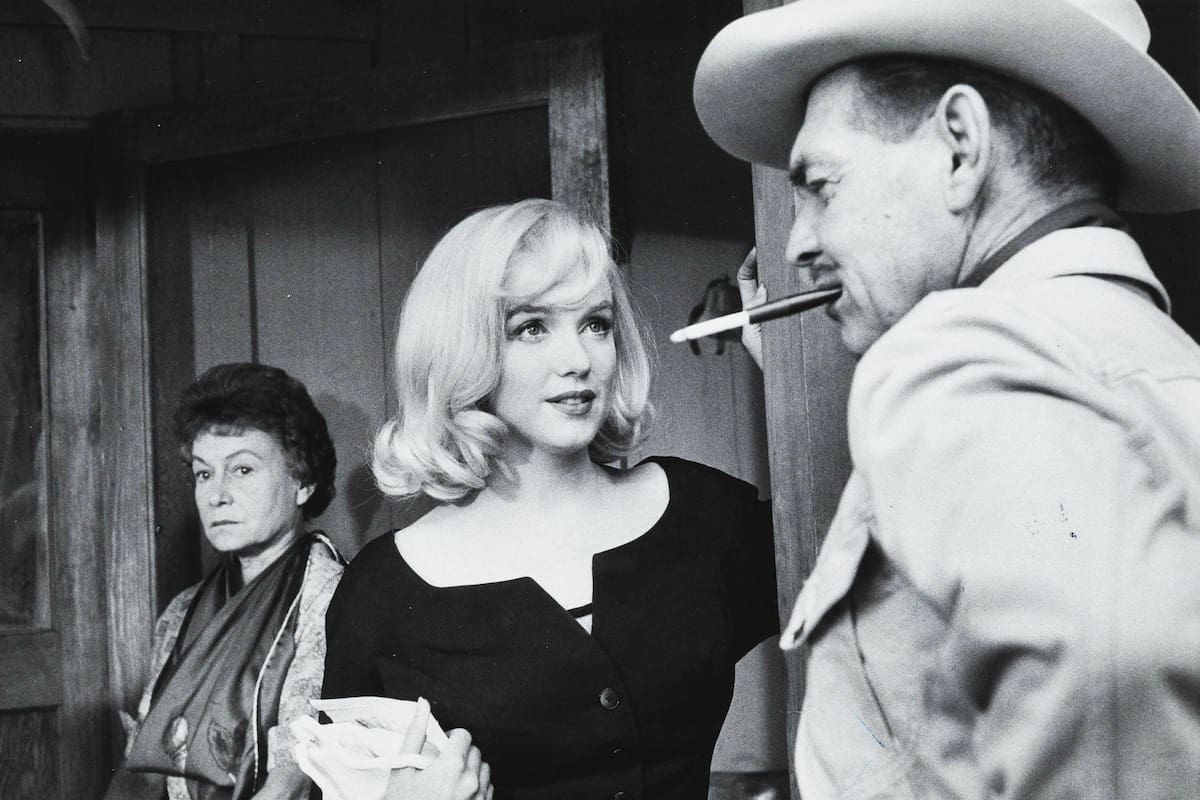Otra de las imágenes del rodaje que muestran a Clark Gable y Marilyn Monroe en conversando, y a Thelma Ritter esperando detrás.