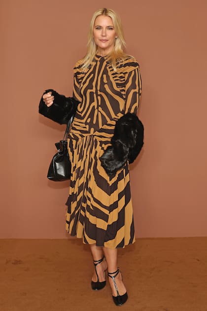 Otro look de alto impacto para ir al desfile de Ferragamo: vestido midi con estampa de cebra y frunces estratégicos, cartera de cuero, stilettos Mary Jane y abrigo de piel sintética