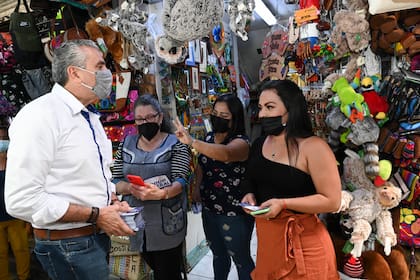Otto Guevara, candidato a la Asamblea Nacional por el Partido Unión Liberal, hace campaña en un mercado, el jueves 3 de febrero de 2022, en San José. (AP Foto/Carlos González)