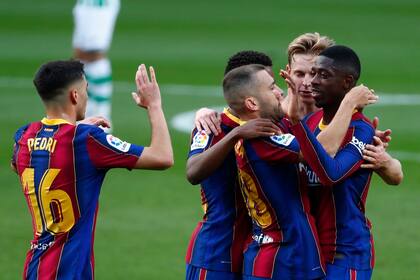 Ousmane Dembélé celebra con sus compañeros de equipo después de anotar el primer gol de su equipo.
