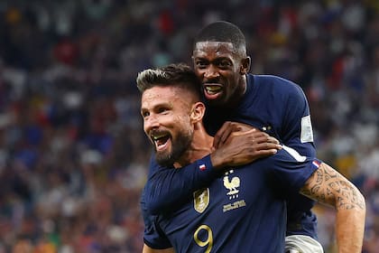 Ousmane Dembelé se cuelga de Olivier Giroud, autor de dos de los cuatro goles que Francia le hizo a Australia en su presentación en el Mundial Qatar 2022.