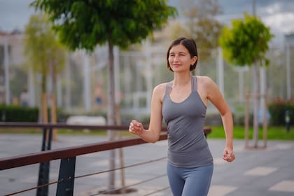 outdoor sports, workout and wellness concept. asian young strong, confident woman in sportive clothes in green park.