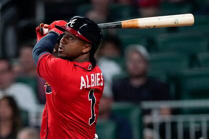 Ozzie Albies, de los Bravos de Atlanta, conecta un doble de dos carreras en el séptimo inning del duelo ante los Marlins de Miami, el viernes 27 de mayo de 2022 (AP Foto/John Bazemore)