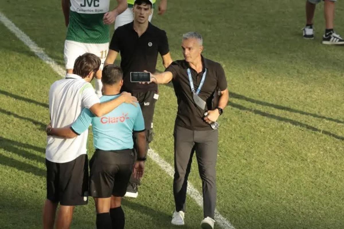 Pablo Lavallén sostiene su teléfono celular y le muestra la jugada polémica