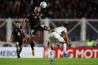 Pablo Monje cabecea ganándole en la altura a Nicolás Meza, de Palestino; Riestra nació a las competencias internacionales con un 0-0 en el Nuevo Gasómetro, por la Copa Sudamericana.