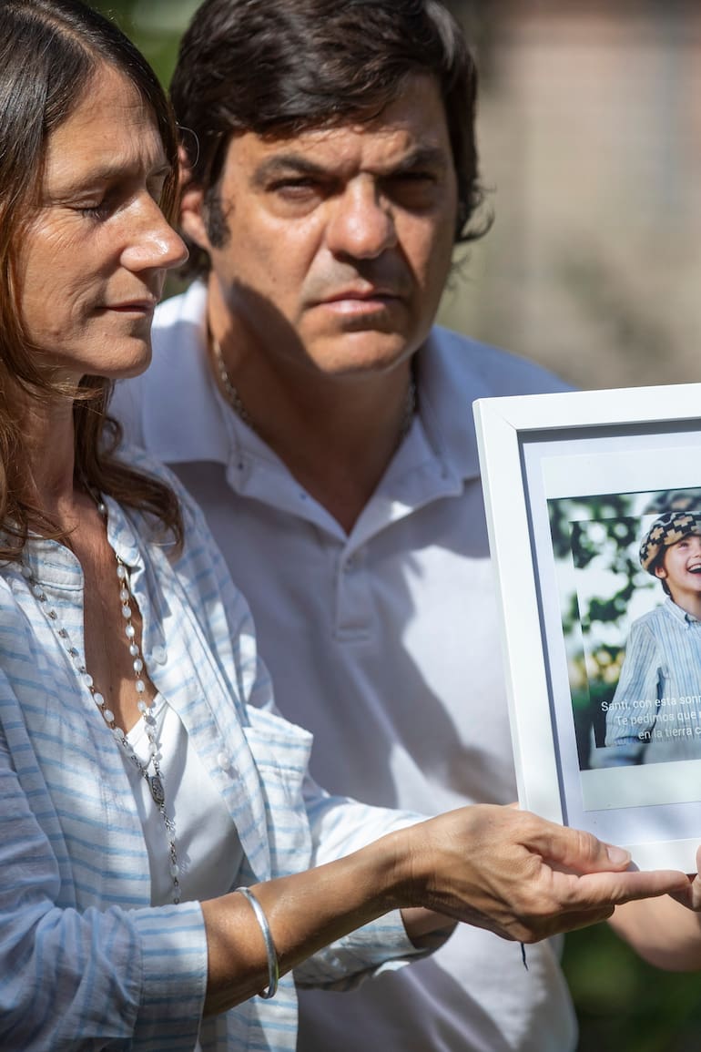 Pablo y Elena sostienen un retrato de su hijo Santiago. "Sentimos que un día se va a abrir la puerta y vas a volver a casa con esa sonrisa tan pura y esos ojitos celestes llenos de alegría, a darnos el abrazo que tanto extrañamos", escribió la madre