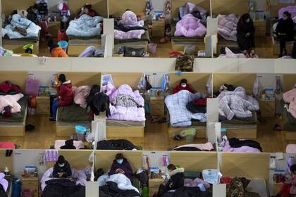 Pacientes infectados descansan en un hospital provisorio en la ciudad china de Wuhan, donde las autoridades tuvieron que construir dos hospitales nuevos para hacer frente a la demanda