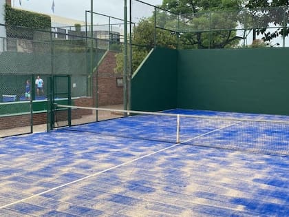 Una cancha para amateurs: ladrillo, alambrado, poco margen externo, arena y cemento debajo del césped artificial.