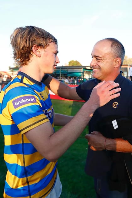 Padre e hijo, con el rugby en el primer plano