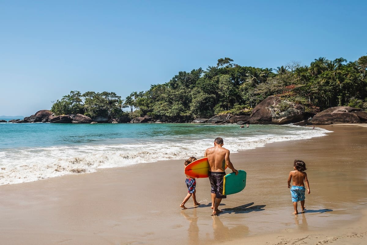 Padre e hijos en la orilla de praia Félix en Ubatuba.
