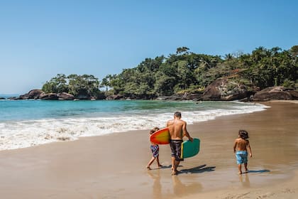 Padre e hijos en la orilla de praia Félix en Ubatuba.