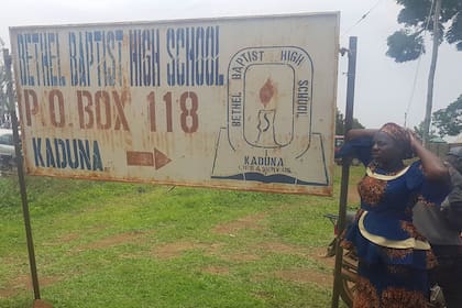 Padres de los chicos secuestrados junto a un cartel indicador de la Bethel Baptist School, en el noroeste de Nigeria