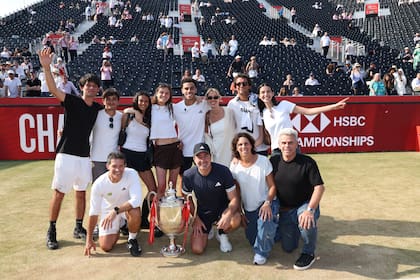 Padres, equipo (entre ellos, el nuevo coach, Nicolás Massú) y allegados de Francisco Cerúndolo, posando con el trofeo del ATP 500 de Queen's