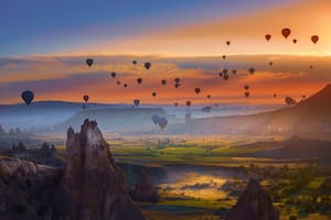 Paisaje de la fabulosa Capadocia (Kapadokya) y los coloridos globos de aire voladores en el cielo al amanecer en Anatolia