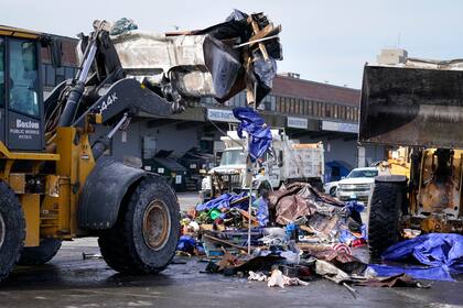Palas mecánicas levantan tiendas de campaña, muebles y otros objetos al desalojar un campamento de indigentes de una calle en Boston el 12 de enero del 2022. (AP Foto/Charles Krupa)