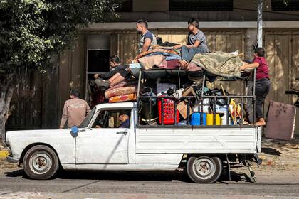 La gente viaja con sus pertenencias en una camioneta antigua mientras evacuan su casa en Rafah, en el sur de la Franja de Gaza, el 1 de noviembre de 2023