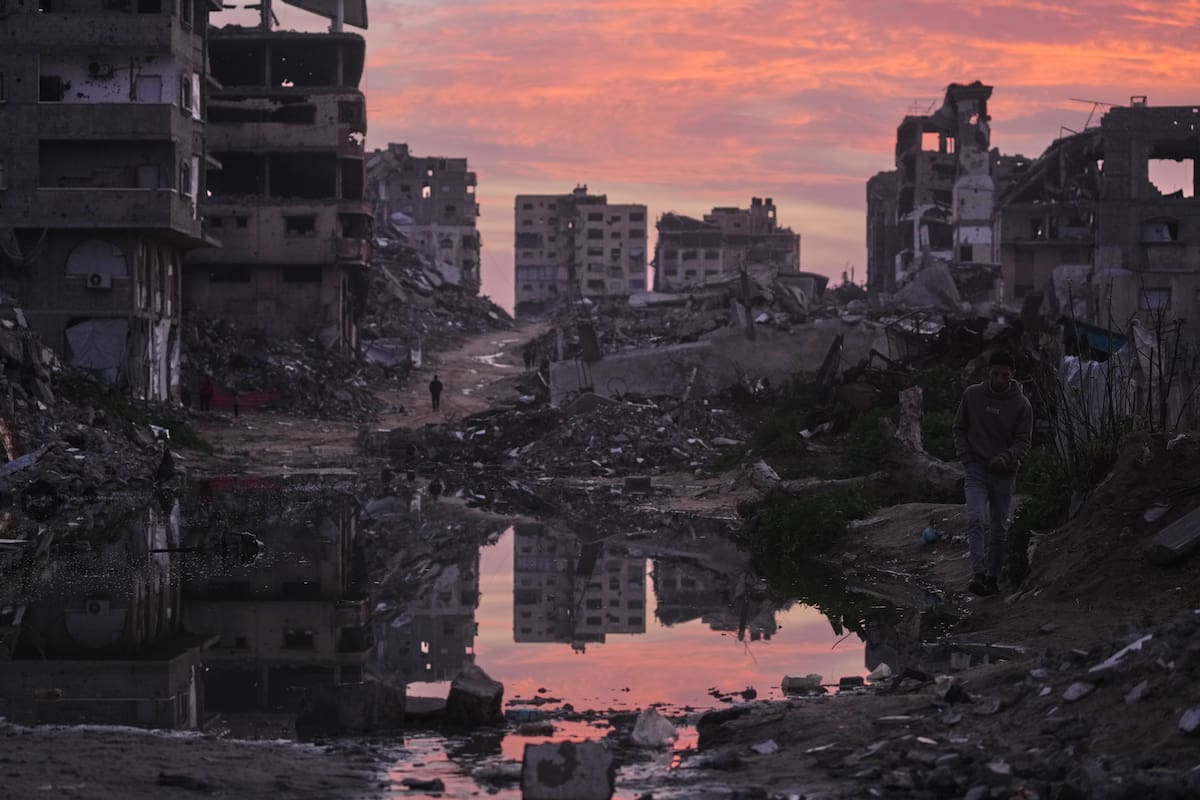 Palestinos caminan entre edificios destruidos por los ataques aéreos y terrestres del ejército de Israel, en la Ciudad de Gaza