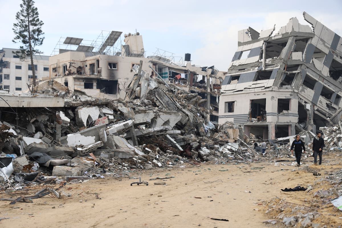 Palestinos caminan junto a un edificio destruido en el bombardeo israelí de la Franja de Gaza, en Ciudad de Gaza, el miércoles 3 de enero de 2024. (AP Foto/Mohammed Hajjar)