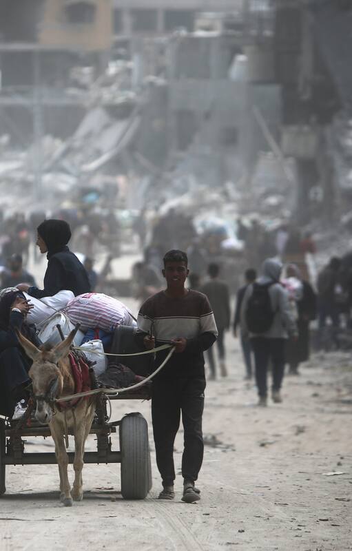 Palestinos con sus pertenencias en Khan Yunis, en la Franja de Gaza (Foto AP /Mohammed Dahman)