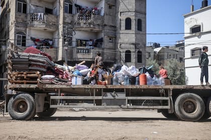 Palestinos desplazados en Rafah, en el sur de la Franja de Gaza, llevan sus pertenencias mientras se marchan tras la orden de evacuación