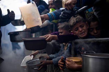 Palestinos hacen fila para recibir comida, en Rafah, en la Franja de Gaza. (AP Foto/Fatima Shbair, archivo)