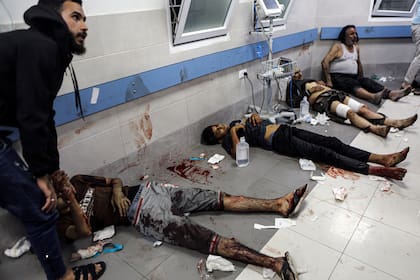 Palestinos heridos acostados en el piso del hospital Al Shifa, en Gaza, Franja de Gaza, el martes 17 de octubre de 2023, luego de llegar del hospital Al Ahli tras una explosión allí.
