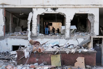 Palestinos inspeccionan los daños a un edificio tras un ataque israelí en el campo de refugiados de Jenín, Cisjordania, el domingo 22 de octubre de 2023.