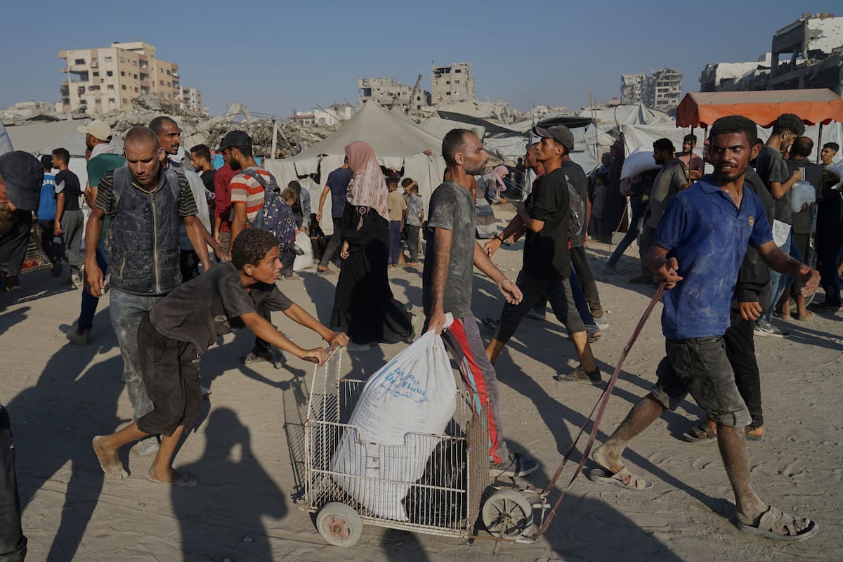 Palestinos llevan sacos de harina entregados por una caravana humanitaria que llegó a Ciudad de Gaza desde el norte de la Franja de Gaza, el sábado 26 de julio de 2025. (AP Foto/Jehad Alshrafi)