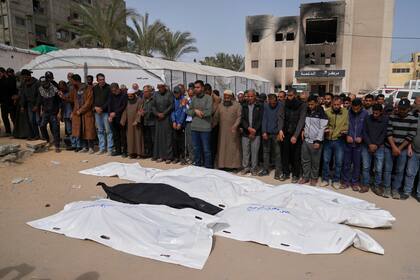 Palestinos oran junto a los cuerpos de cinco de las personas que murieron en el ataque contra Khan Yunis, en el sur de la Franja de Gaza