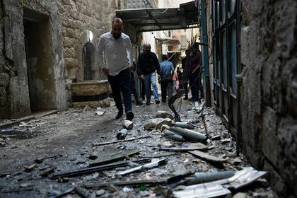 Palestinos reunidos en el lugar donde fuerzas israelíes destruyeron un laboratorio de explosivos de un grupo armado identificado como Guarida de Leones en la localidad de Nablus, en la Cisjordania ocupada, el martes 25 de octubre de 2022. (AP Foto/Majdi Mohammed)