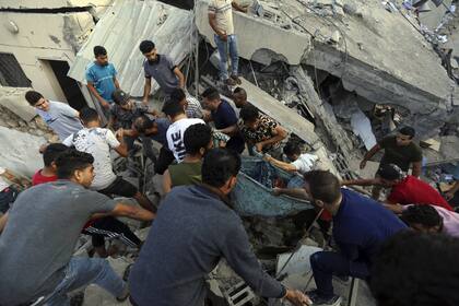 Palestinos sacan un cuerpo entre los escombros de una iglesia ortodoxa en Gaza