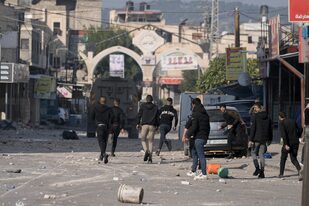Palestinos se enfrentan a las fuerzas de seguridad israelíes tras una redada del ejército en la ciudad cisjordana de Yenín, el 26 de enero de 2023. (AP Foto/Majdi Mohammed)