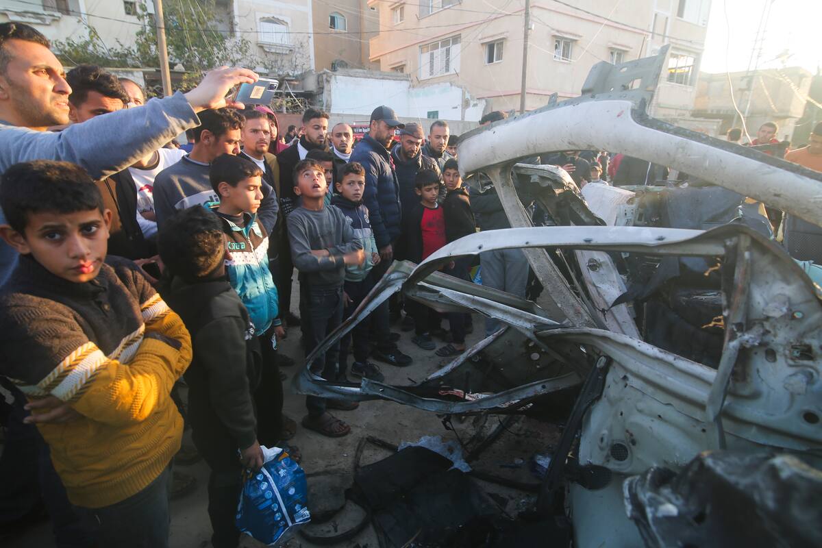 Palestinos se reúnen alrededor de un coche de la policía de Hamas que fue alcanzado por un ataque aéreo israelí, en Rafah, en la Franja de Gaza, el 6 de febrero de 2024. (AP Foto/Hatem Ali)