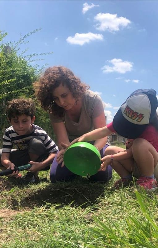 Mariel Klosewicz junto a sus hijos Lorenzo y Renata haciendo tareas de huerta en el jadín de su casa