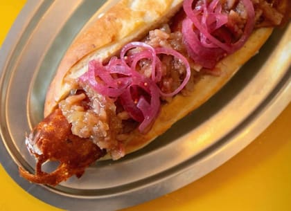 Pancho con chutney de manzana, queso fontina y pickles de cebolla morada, en Rusvel.
