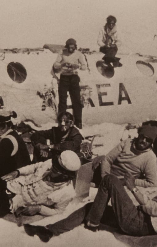 Pancho Delgado, sentado en el techo del fuselaje, y Roberto Canessa (de pie), tejen tela aislante. Recostados: Fito Strauch, Carlitos Páez, Gustavo Zerbino, Eduardo Strauch, Nando Parrado y Javier Methol.