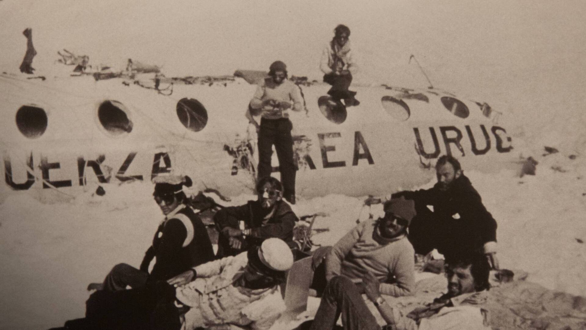 Pancho Delgado, sentado en el techo del fuselaje, y Roberto Canessa (de pie), tejen tela aislante. Recostados: Fito Strauch, Carlitos Páez, Gustavo Zerbino, Eduardo Strauch, Nando Parrado y Javier Methol.