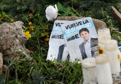 Panfletos con la imagen del senador colombiano Miguel Uribe Turbay, junto a velas y flores, colocadas junto al lugar en el que fue disparado