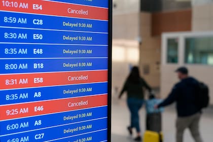 Pantalla de video muestra retrasos y cancelaciones de vuelos en el Aeropuerto Nacional Ronald Reagan de Washington en Arlington, Virginia