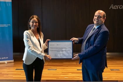 Paola Tamburelli le entregó a Pablo Ceriani, presidente de Aerolíneas Argentinas el certificado que lo habilita a operar bajo el mismo código que Austral