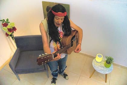 Peluca, musculosa, collares, guitarra, el estilismo que le da identidad a Paolo