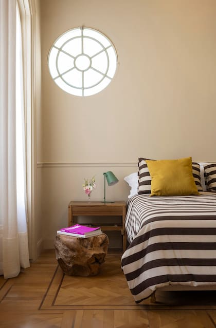 Para captar más luz, agregaron este ojo de buey y una puerta-ventana hacia el jardín. mesa de noche (Marini) y tronco (Mono Giraud). Todo el ambiente fue pintado en el tono ‘Kilim Beige’ (Sherwin Williams).