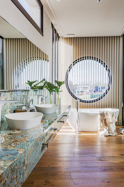 Para darle privacidad a este baño espectacular, la arquitecta Gabriela Barrionuevo eligió unas cortinas de bandas verticales (Hunter Douglas) a tono con el piso y las vetas del mármol ‘Étoile Illusion’ (SBG).