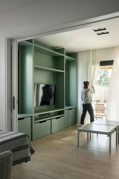 Para descontracturar este ambiente, que usan mucho los chicos, hicieron un mueble de MDF laqueado verde.