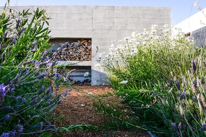Para disfrutar el living exterior se construyó una chimenea en el muro de contención.