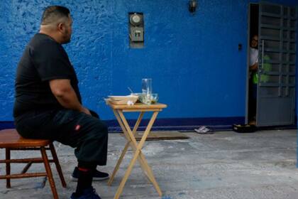 Para evitar contagiarlos, el médico come alejado de su familia. Fuente: Reuters